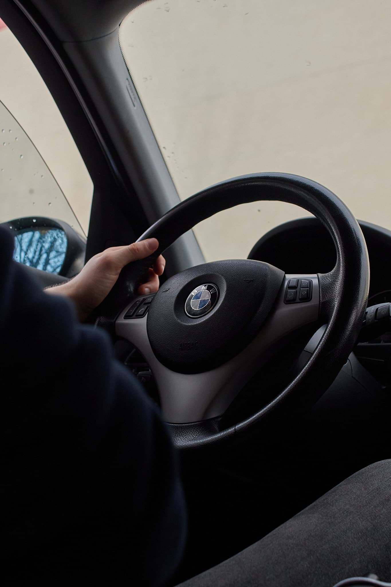 Ranka ant vairo automobilio viduje, matomas BMW logotipas