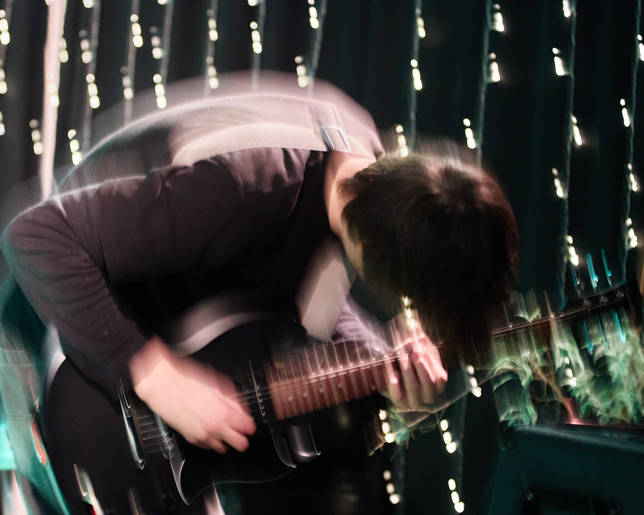 Gitaristas scenoje nufotografuotas su ilgesniu išlaikymu ir judesio efektu