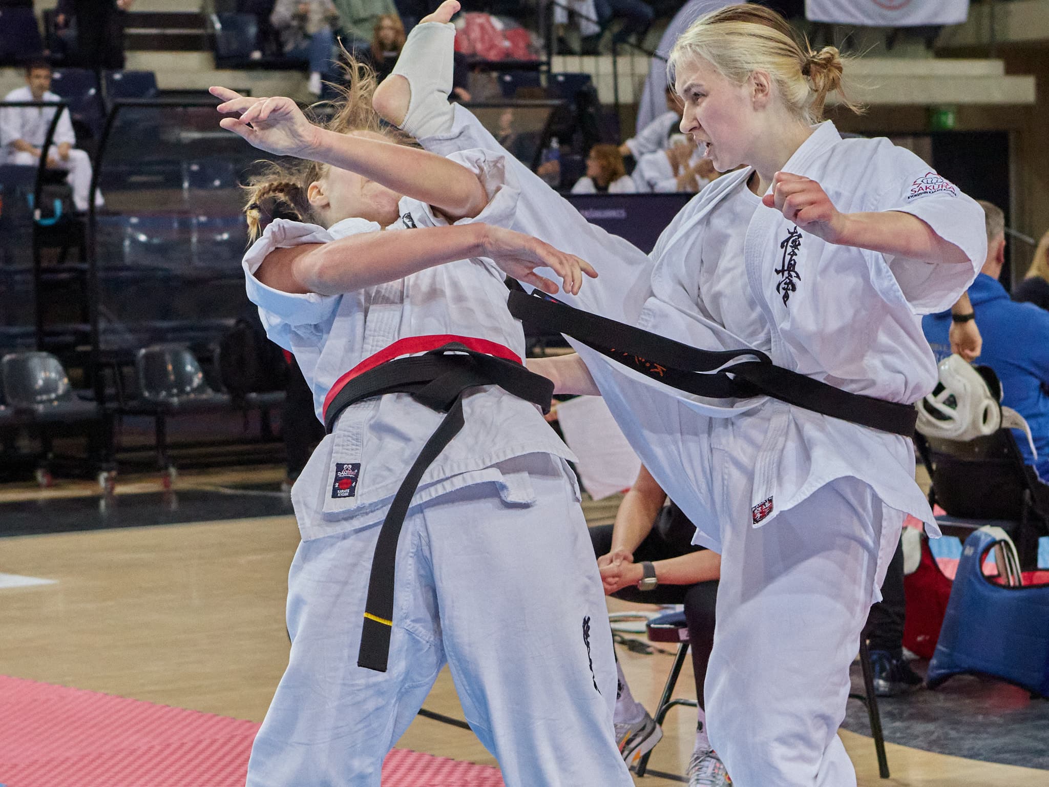 Dvi sportininkės atlieka kovinį veiksmą karatė čempionate