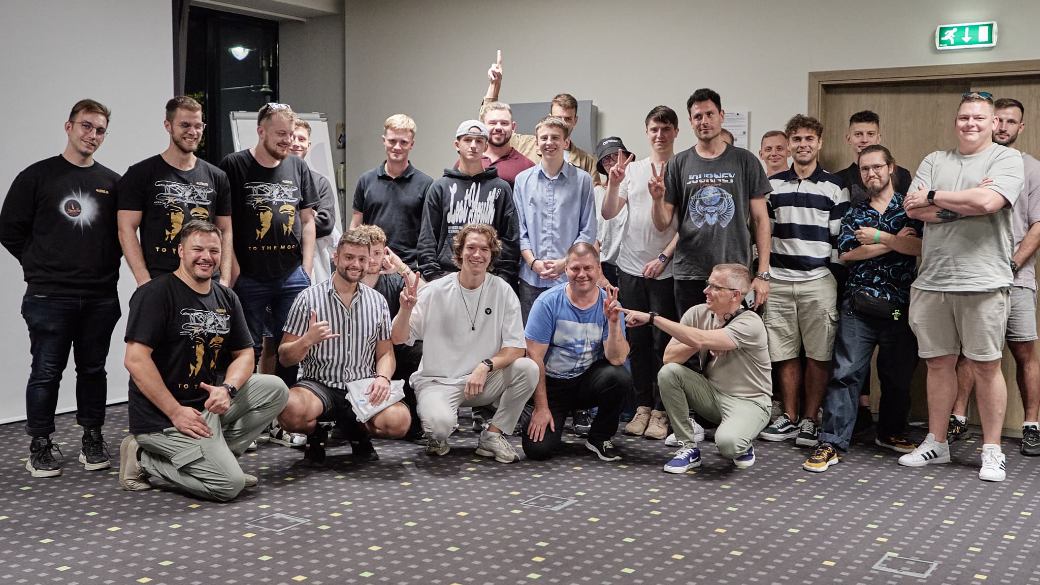 Didelė dalyvių grupė po renginio pozuoja bendram kadrui salėje